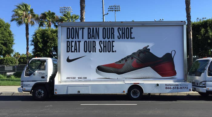 A truck-side advertisement displays a Nike sneaker with text: &quot;DON&#x27;T BAN OUR SHOE. BEAT OUR SHOE.&quot; and a phone number for nationwide service