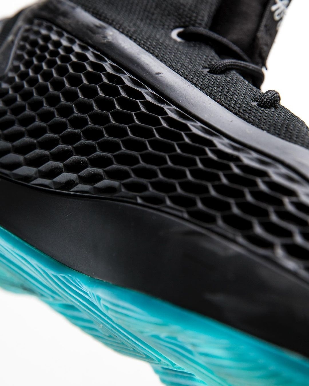 Close-up image of a modern sneaker showcasing a textured honeycomb design on the side and a patterned sole