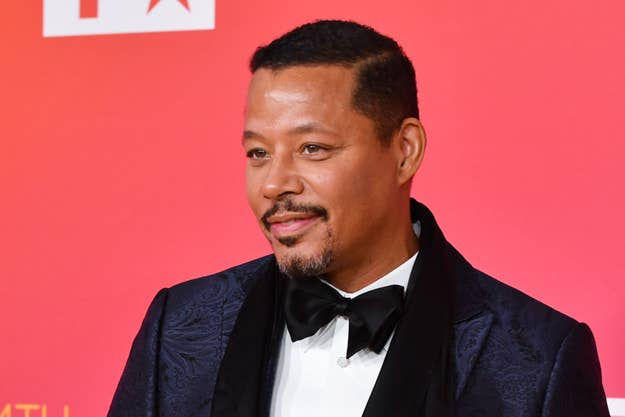 Terrence Howard at a red carpet event, wearing a black tuxedo with a bow tie and a patterned jacket