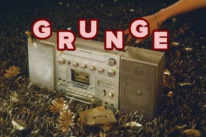 A large vintage boombox sits on a grass field with gold flowers and cassette tapes. The word "GRUNGE" in bold letters is placed above the boombox