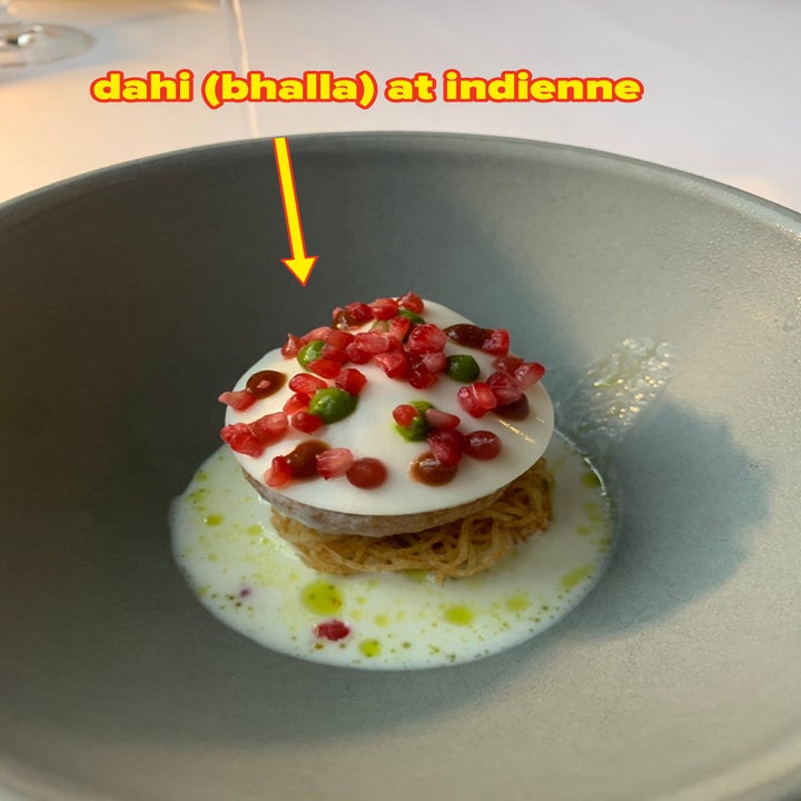 A dish of Dahi Bhalla, served in a gray bowl, garnished with vibrant toppings, at the restaurant Indienne