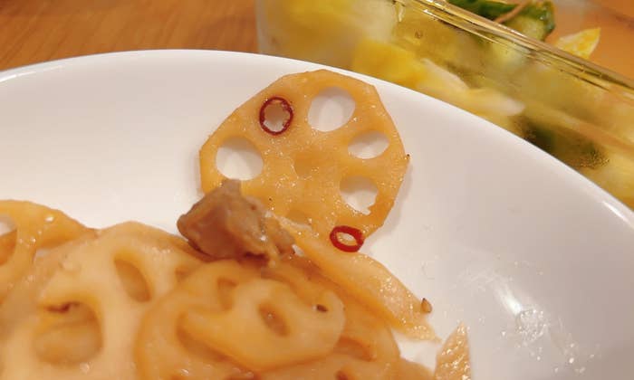 白い皿に盛られた蓮根の料理。右側に透明な容器に入った別の料理が見える。