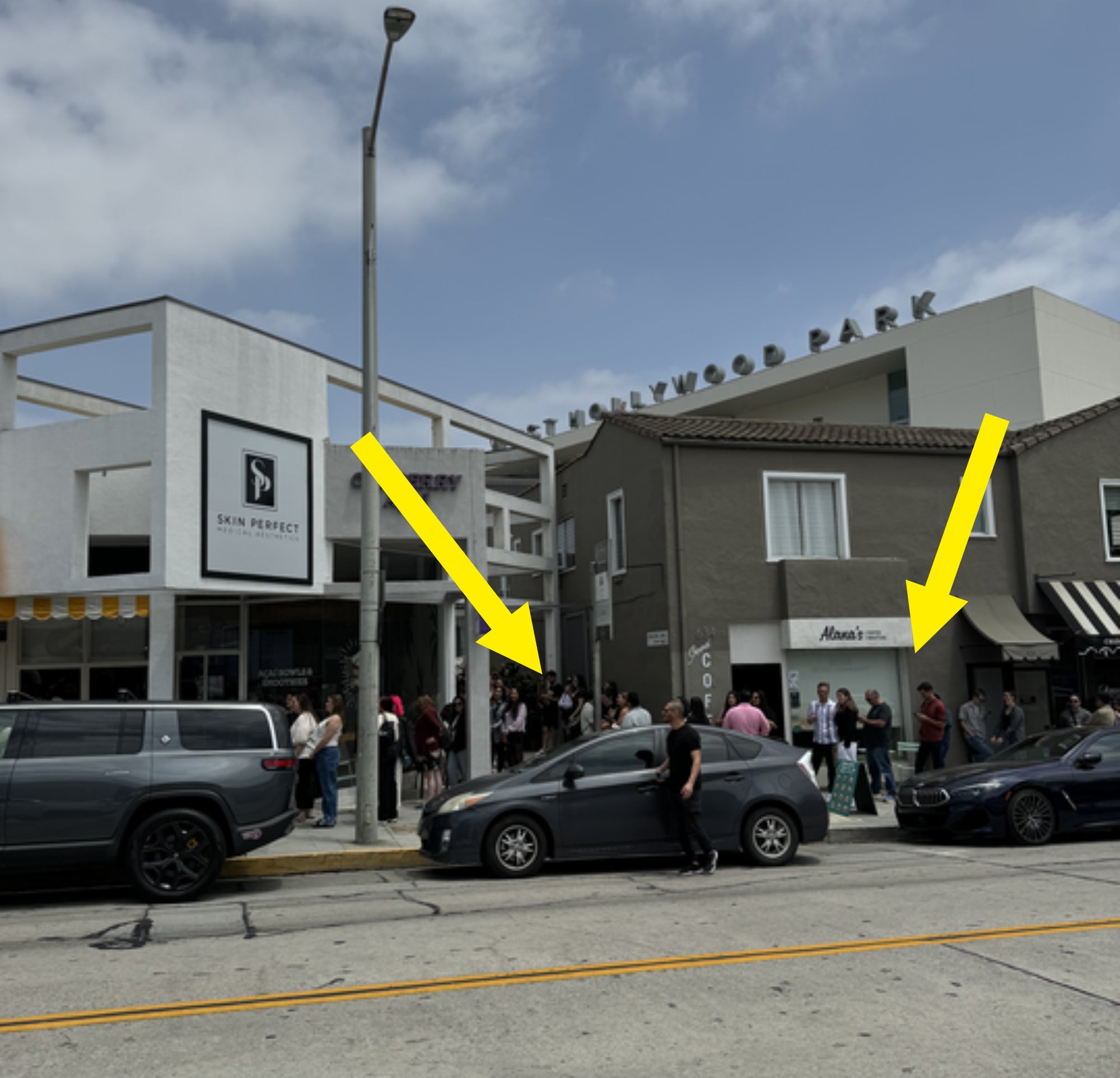 People gather outside Something About Her sandwich shop on the sidewalk in West Hollywood.