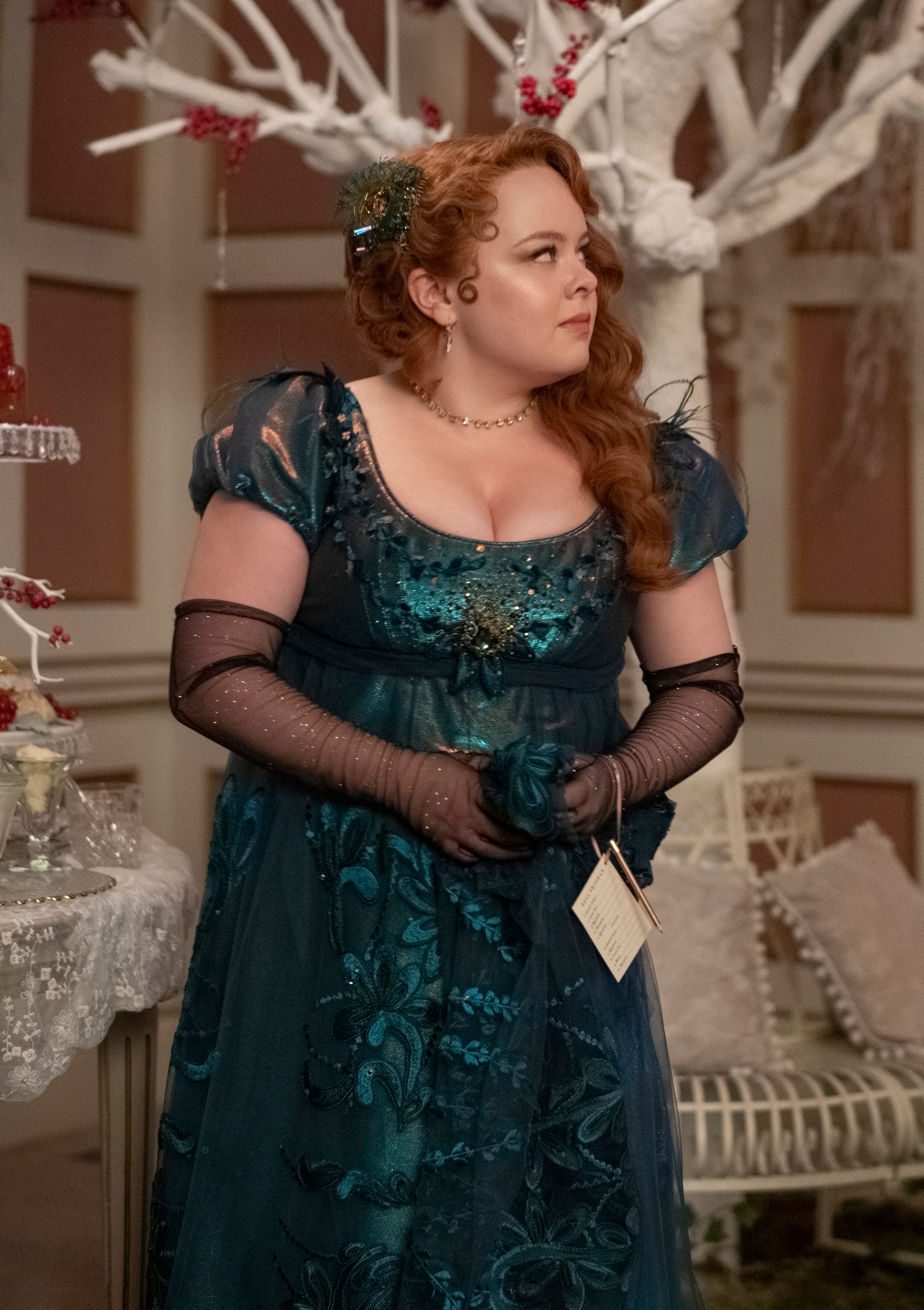 Penelope in her fancy dress and sheer gloves standing in the corner at a party