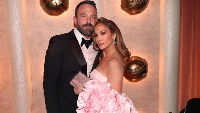 Ben Affleck in a tuxedo and Jennifer Lopez in an off-the-shoulder gown with ruffled sleeves at a glamorous event