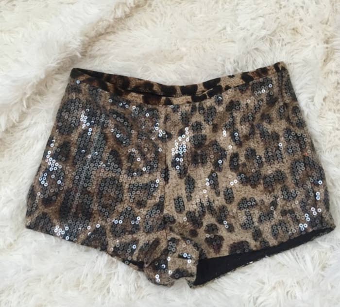 Sequined leopard print shorts lying on a fluffy fabric