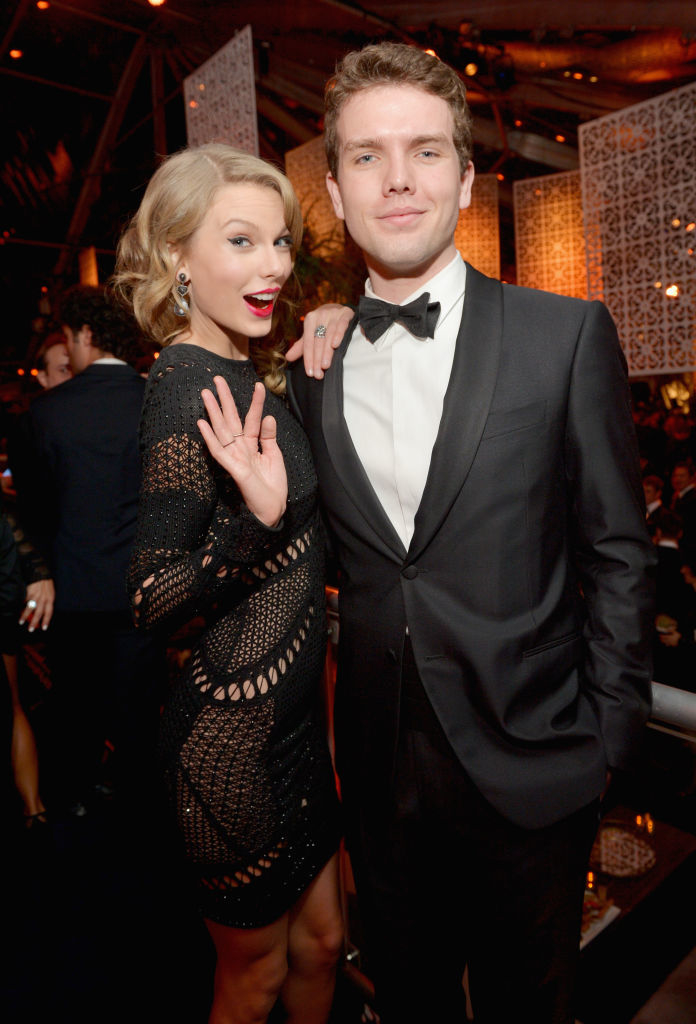 Taylor Swift, wearing a stylish dress with cutouts, and Austin in a classic tuxedo, posing together at a formal event