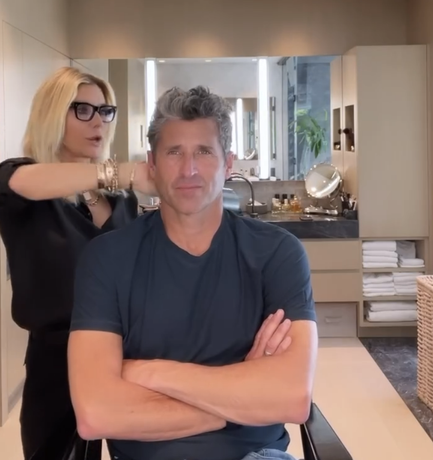 Patrick Dempsey sits in a salon chair with arms crossed, getting his hair styled by Jillian Dempsey