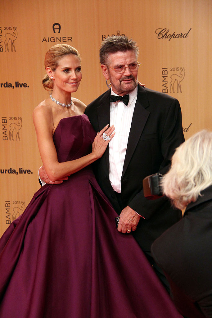Heidi Klum, in an elegant strapless gown, posing with her father a tuxedo at the Bambi Awards 2015, being photographed by a photographer
