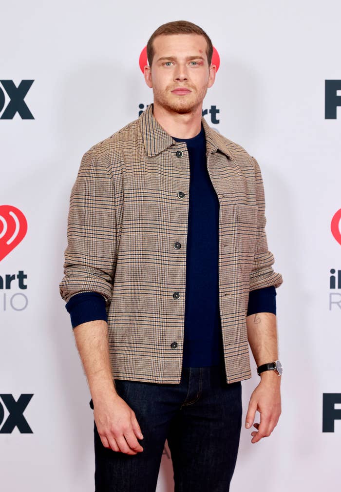 Man on red carpet in casual jacket and dark jeans at iHeartRadio event
