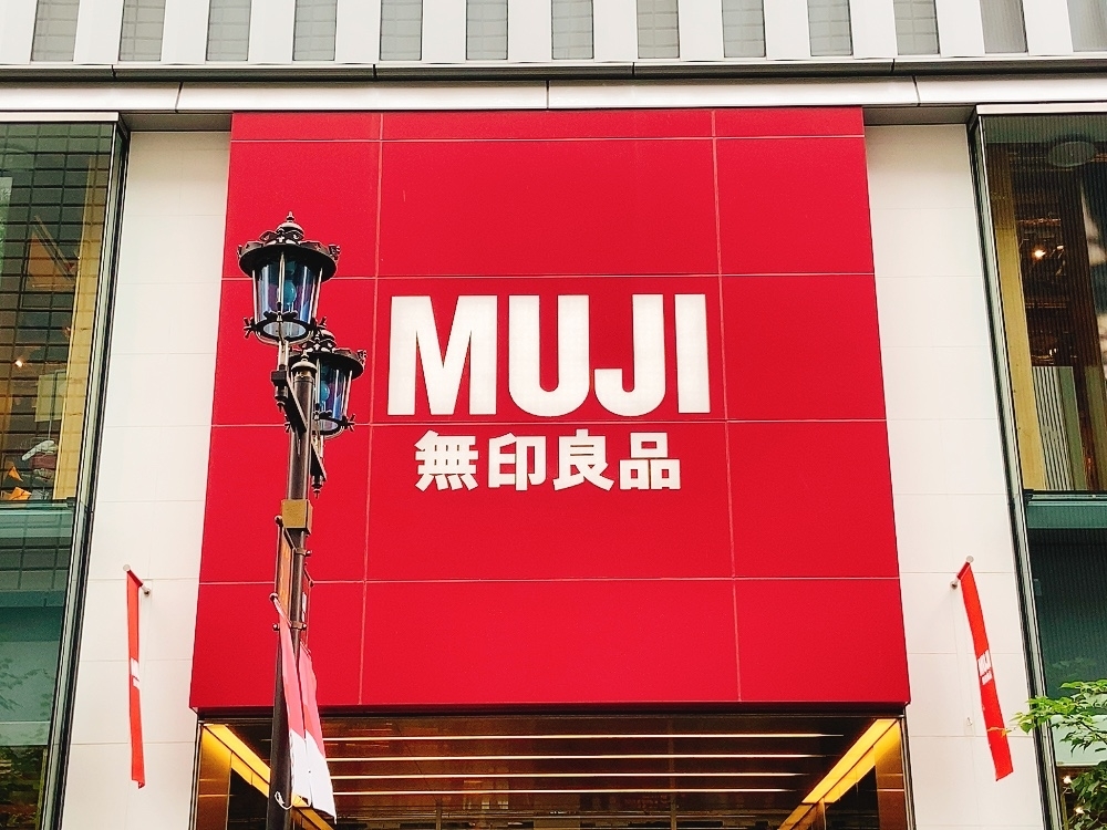 MUJI無印良品の大きな看板が建物の入口の上に掲げられている。