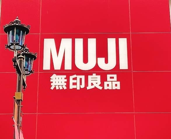 MUJI無印良品の大きな看板が建物の入口の上に掲げられている。
