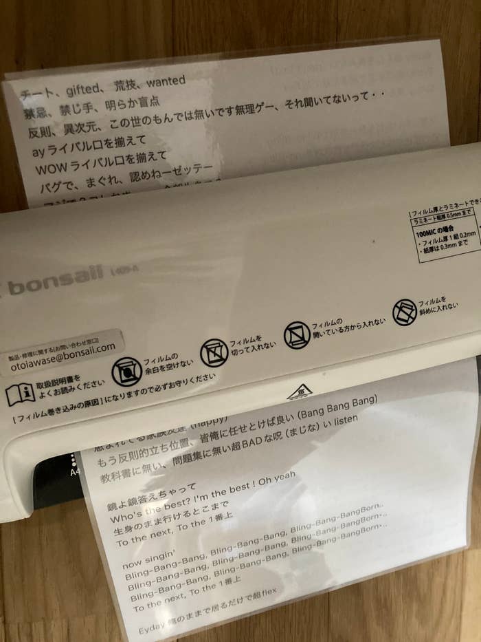 テキストが印刷された紙が数枚写っています。内容は主に歌詞と一部英語のメッセージです。