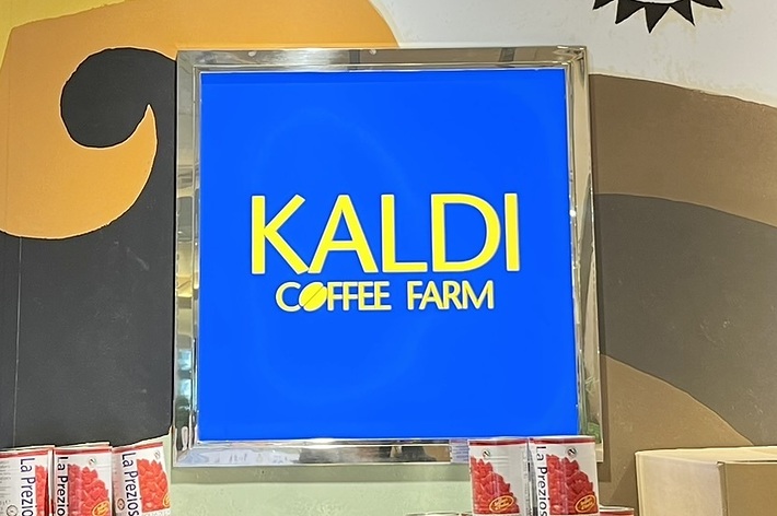 カルディコーヒーファームの店内、商品とイラストが描かれた壁が見える。