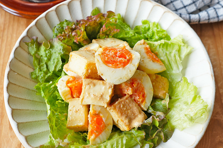 皿に盛られたサラダ。レタスの上に刻んだ野菜とゆで卵が載せられている。