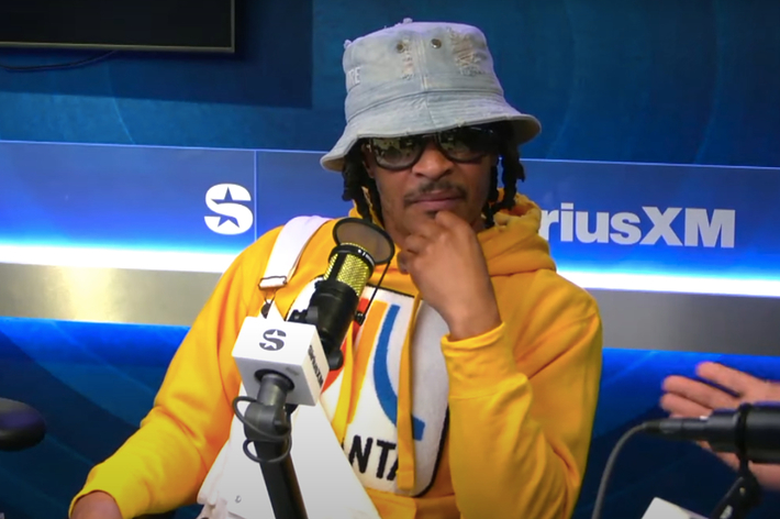T.I. in a yellow hoodie and bucket hat, sits in a radio studio for an interview at SiriusXM