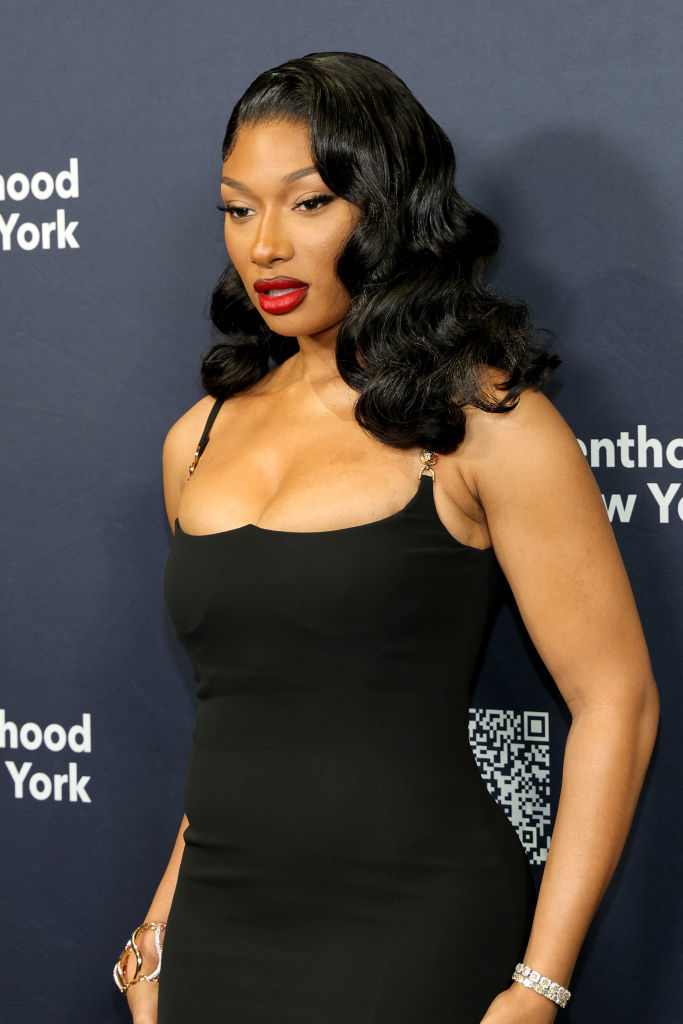 Megan Thee Stallion wearing a sleek, fitted dress with thin straps at a public event