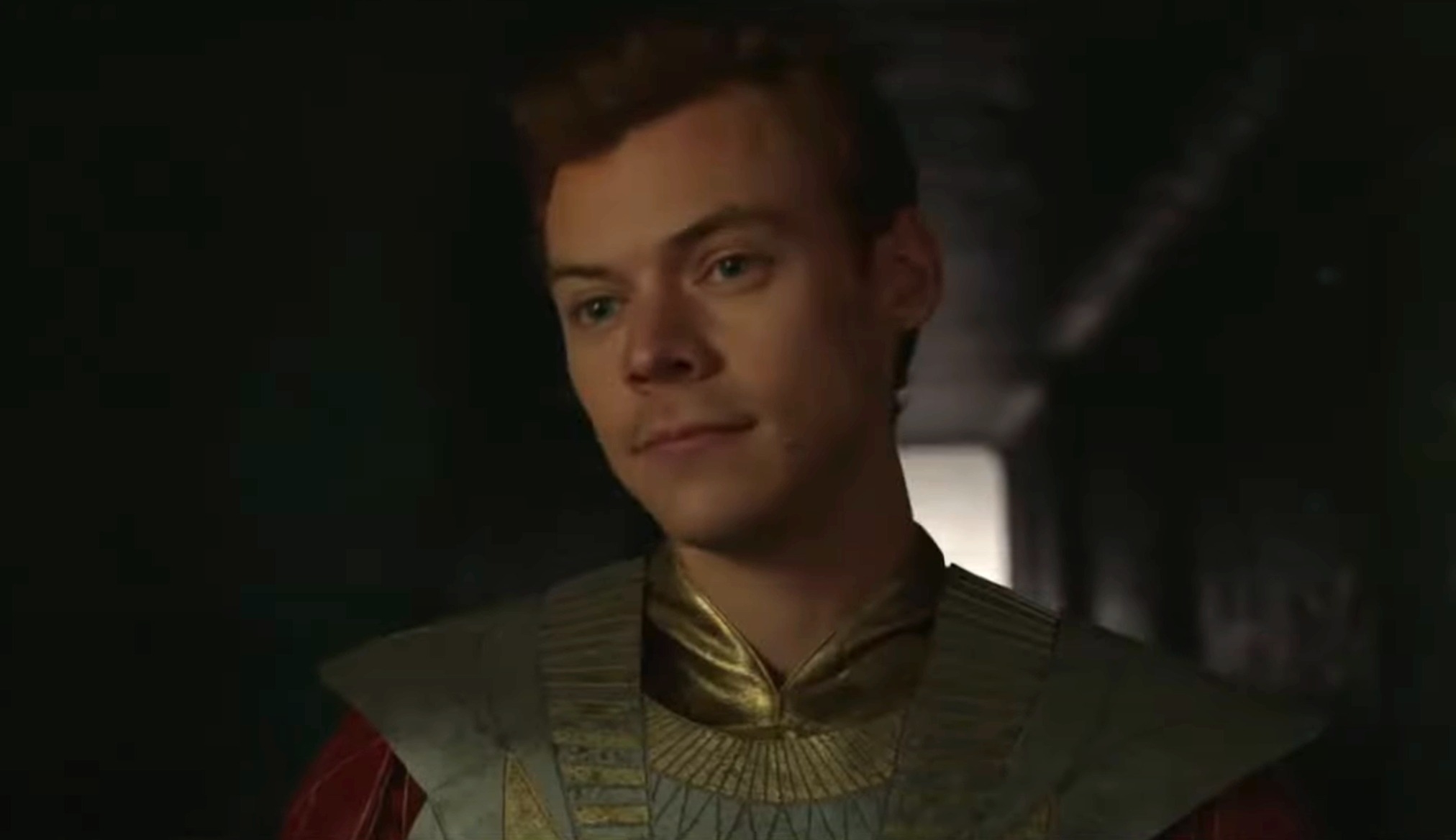 Harry Styles in futuristic costume with metallic and patterned details in a scene