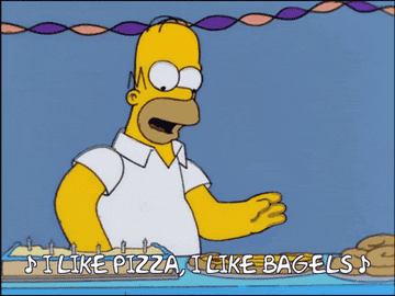Homer Simpson sings while making food. Text displayed: "I like pizza, I like bagels."