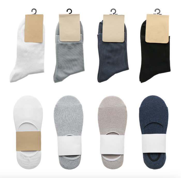 Eight pairs of socks in various lengths and colors are displayed, each with cardboard packaging. The socks are arranged in two rows of four pairs each