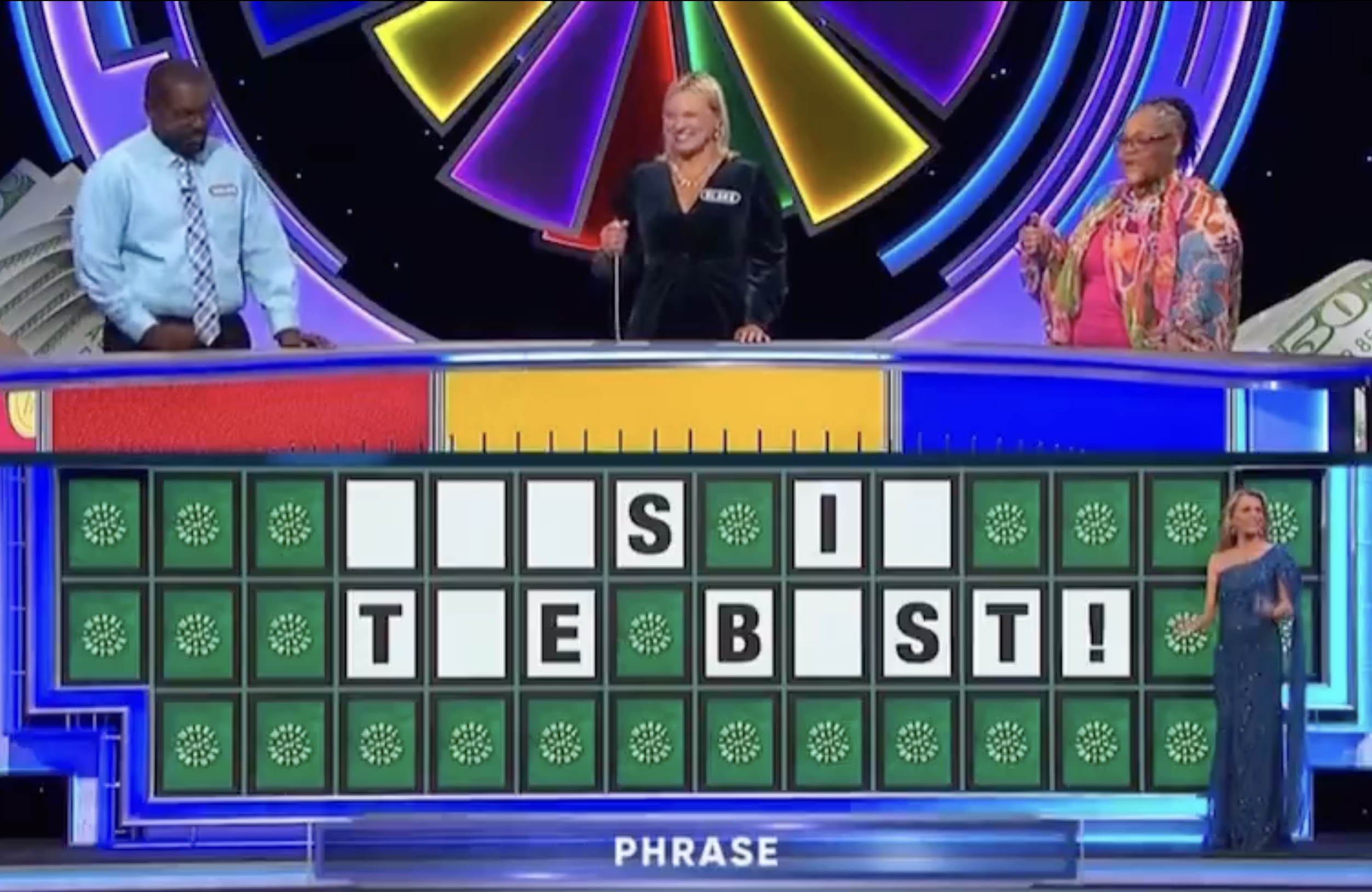 Contestants on Wheel of Fortune, with Vanna White standing next to the board, solving the phrase "THIS IS THE BEST."