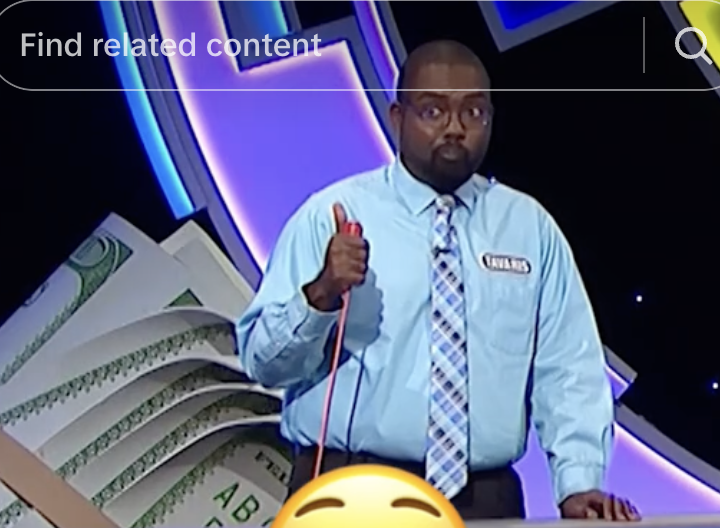 Contestant holding a buzzer on a game show stage with large prop money in the background. A smiling emoji overlay partially covers the image