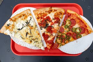 Three slices od New York pizza on paper plates on a tray