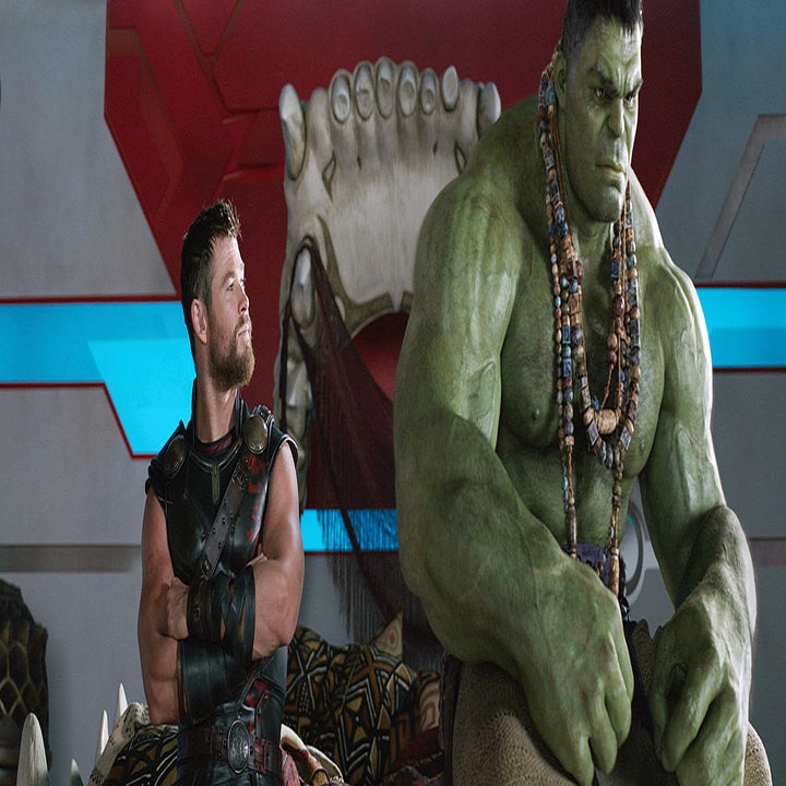 Chris Hemsworth as Thor and Mark Ruffalo as Hulk in a scene from a movie. Thor is in battle armor and Hulk, green and muscular, is wearing beads and sitting nearby