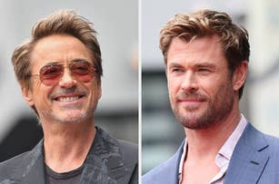 Robert Downey Jr. and Chris Hemsworth smiling, posing during a public appearance. Both are dressed in stylish suits