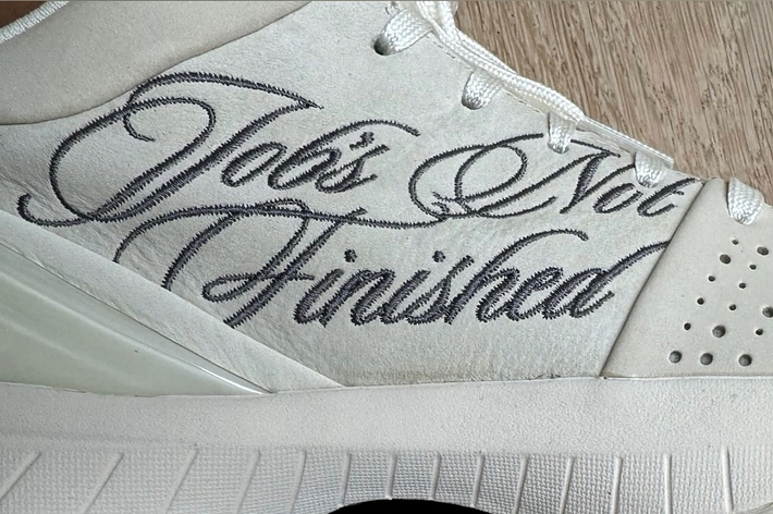 Close-up of a sneaker with the embroidered text "Job's Not Finished."