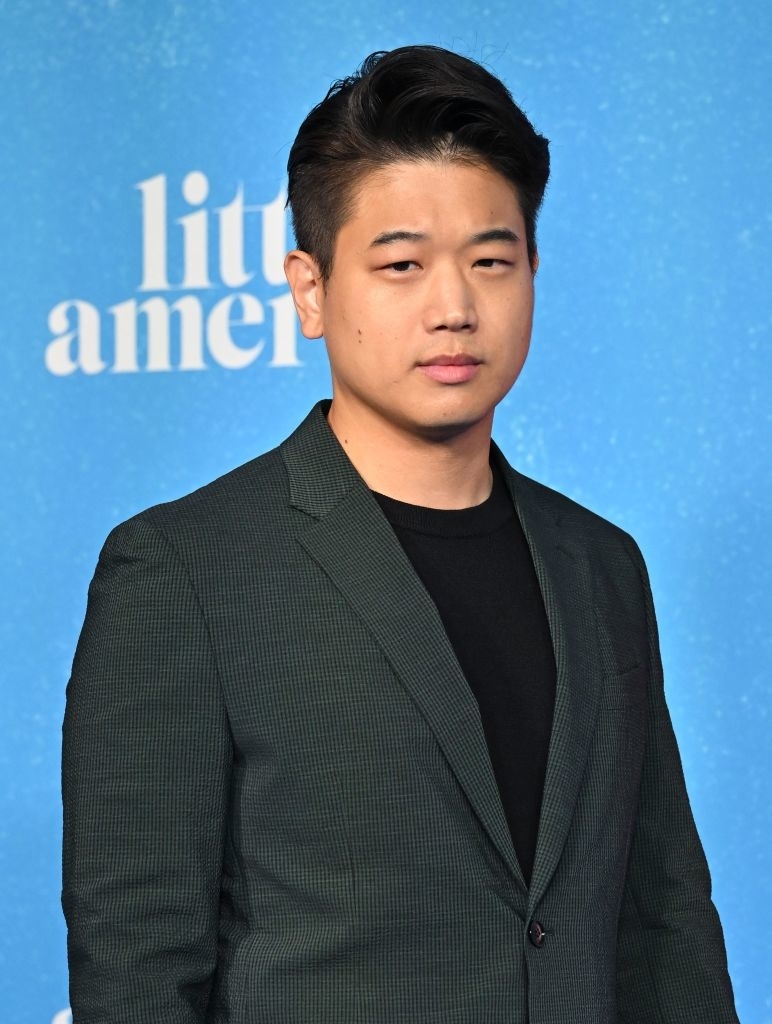 Young Mazino poses in a dark blazer over a black shirt at a 'Little America' event