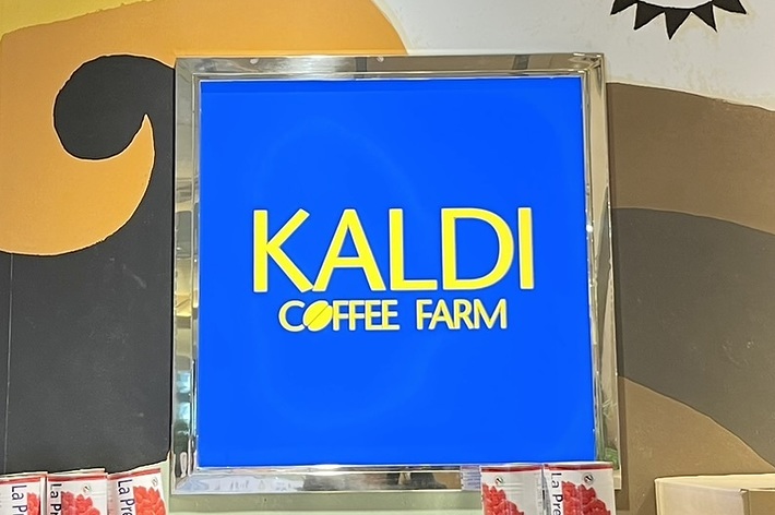 KALDI COFFEE FARMの看板があり、背景には壁画と棚、そして商品の箱が見えるストアの内部です。