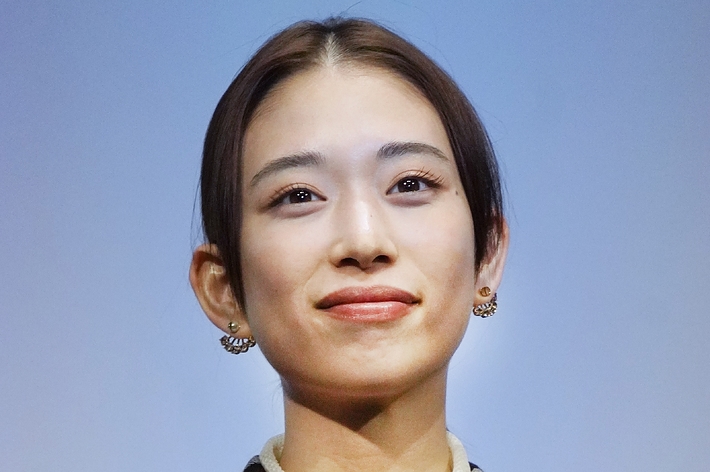 誰が写っているかわかりませんが、チェックスーツを着た女性の胸から上の写真です。