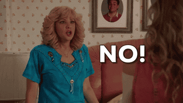 Beverly Goldberg from "The Goldbergs" angrily shouts "NO!" at Erica Goldberg in a bedroom, with a framed photo of Barry Goldberg on the wall