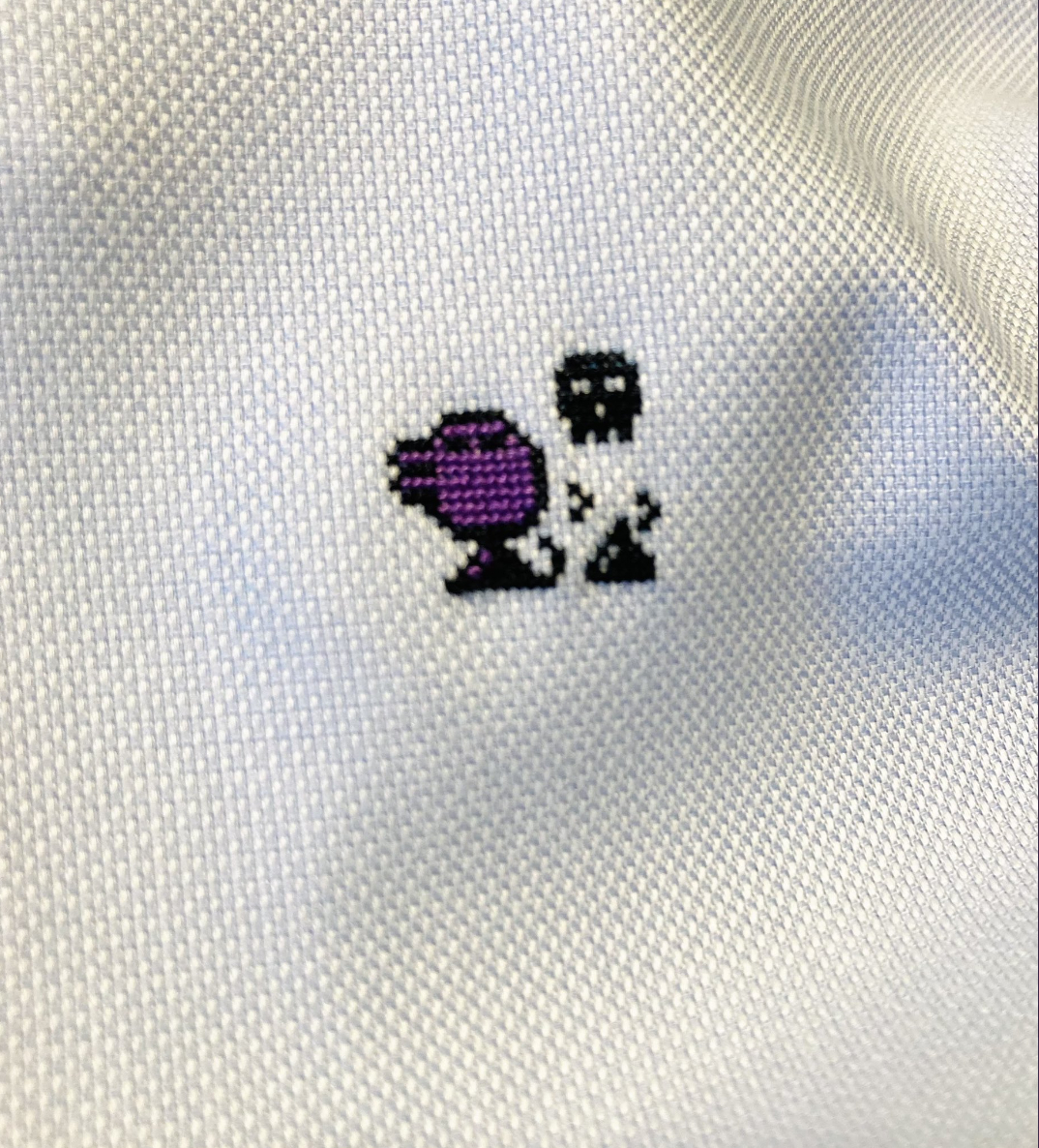 白い布地にパンチの対戦を模した小さな刺繍が施されています。