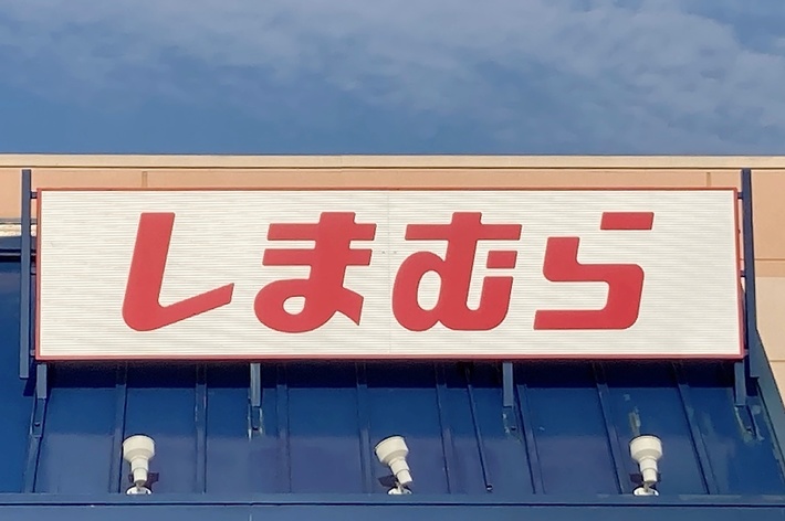 The image shows the front facade of a store with a large sign displaying Japanese characters above the entrance