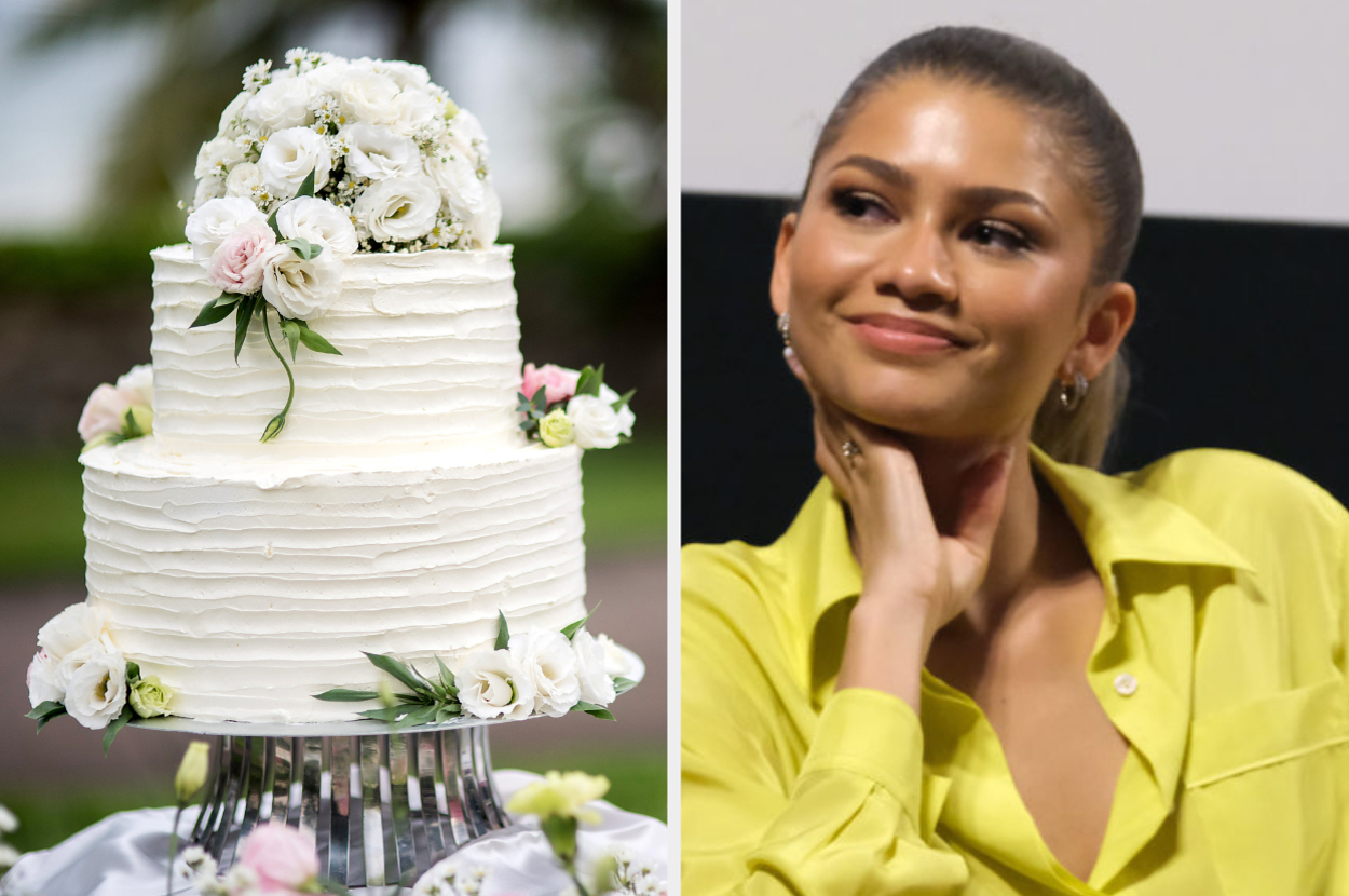 Zendaya in a bright, buttoned-up shirt poses with her chin on her hand. A two-tiered wedding cake adorned with white and pink flowers is next to her