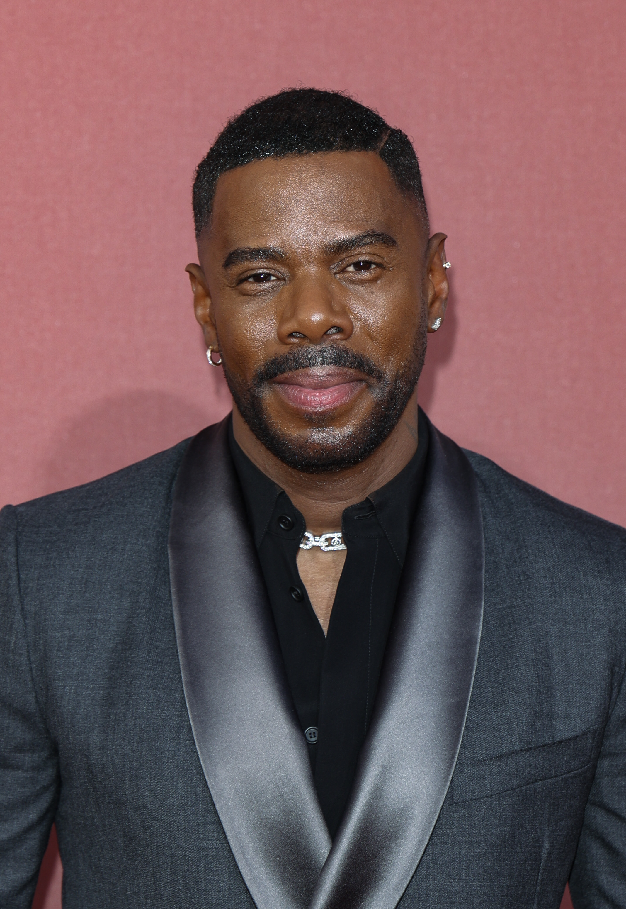 Colman Domingo in a dark suit with a satin lapel and a subtle smile, attending an event