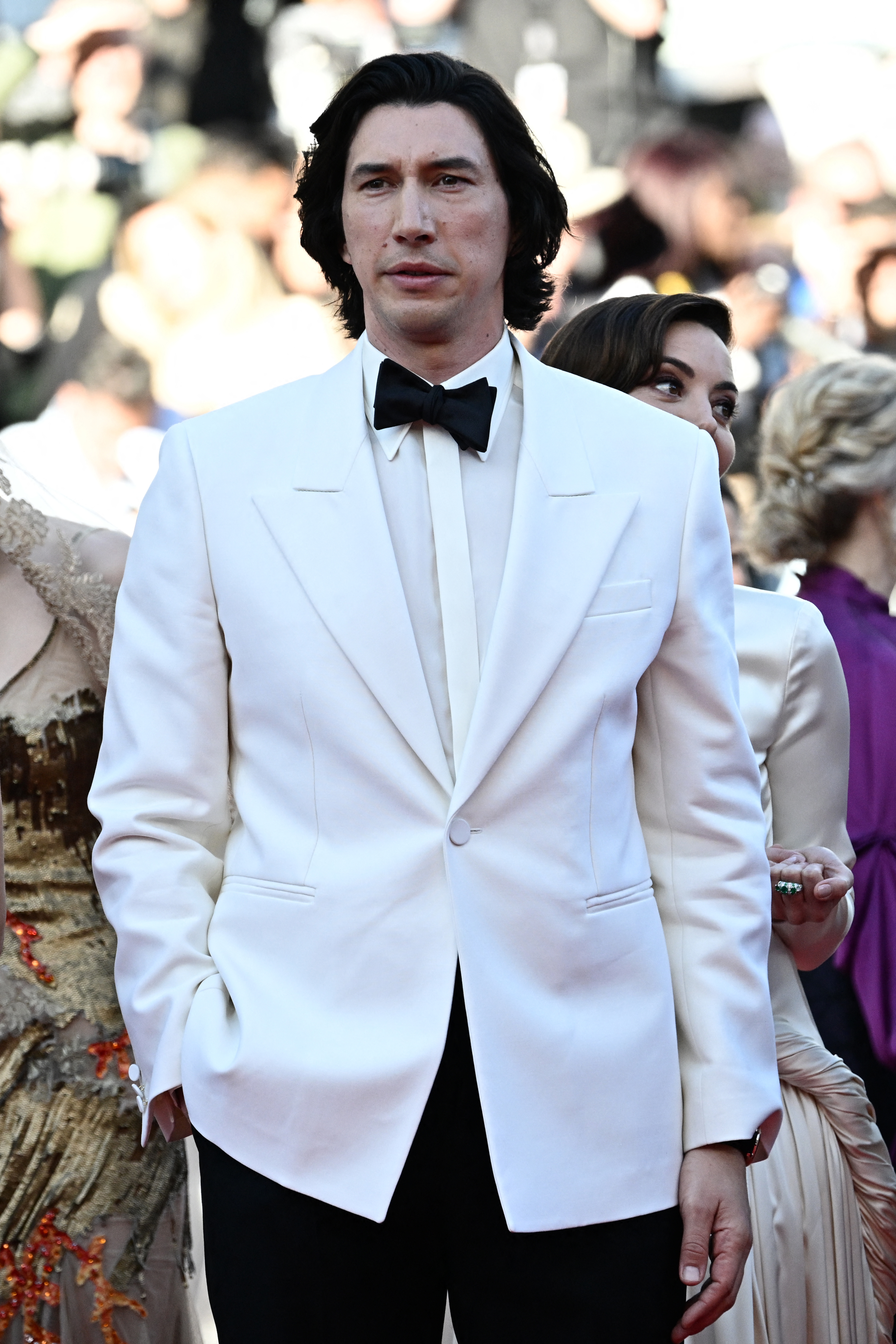 Adam Driver is seen on the red carpet wearing a white tuxedo with a black bow tie