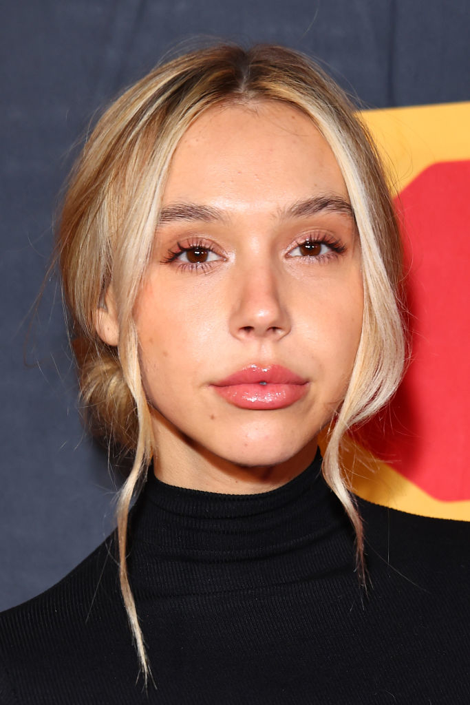 close up of Alexis Ren in a turtleneck posing for a photo on red carpet