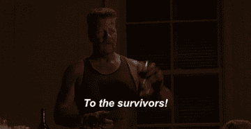 Man in a tank top holds up a glass, with the caption &quot;To the survivors!&quot; in the scene