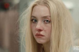 Hunter Schafer with a distressed expression and disheveled hair, appears to have a bruised nose. HBO logo is visible in the frame