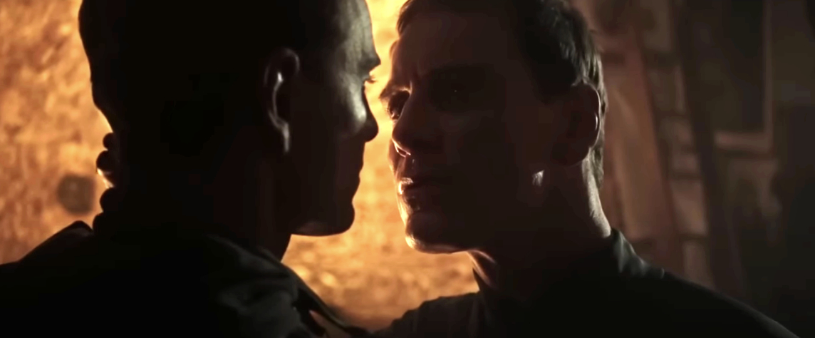 Michael Fassbender closely faces another Michael Fassbender in a dark, dramatic scene from a movie