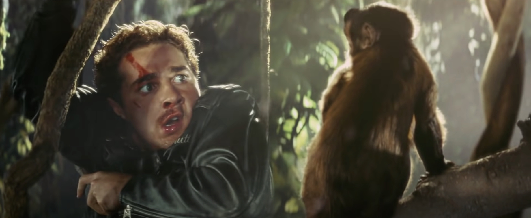 A scene from the movie &quot;Nope&quot; showing Brandon Perea&#x27;s character frightened, with a red mark on his forehead, and a monkey staring at him