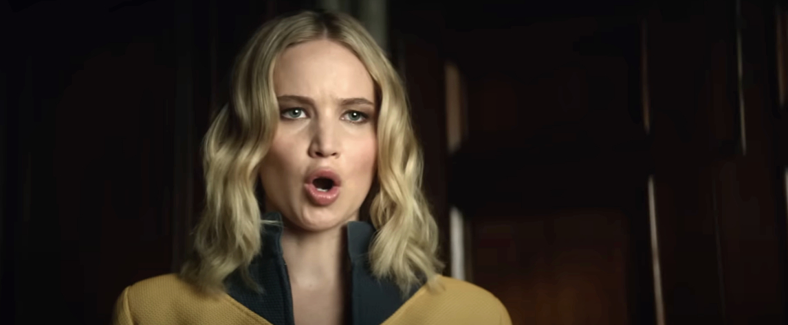 Jennifer Lawrence delivers an intense expression in a scene from the movie &quot;Don&#x27;t Look Up,&quot; wearing a jacket with a high collar