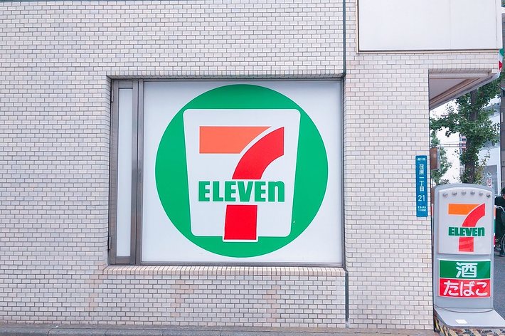 セブンイレブンの店頭ロゴとサインが掲示された壁