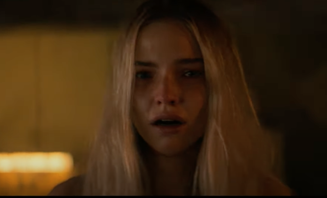 Sasha Luss looks forward with an open mouth and distressed expression
