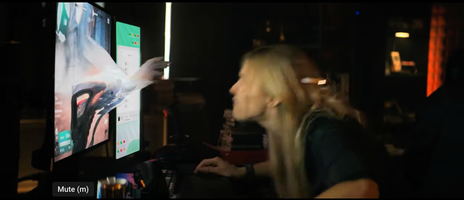 A woman with long blonde hair leans in closely towards a computer screen, focusing intently on what is displayed