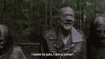 Jeffrey Dean Morgan, blindfolded and in a leather jacket, is flanked by two zombie-like figures in a forest. Text: &quot;I want to join, I am a joiner!&quot;