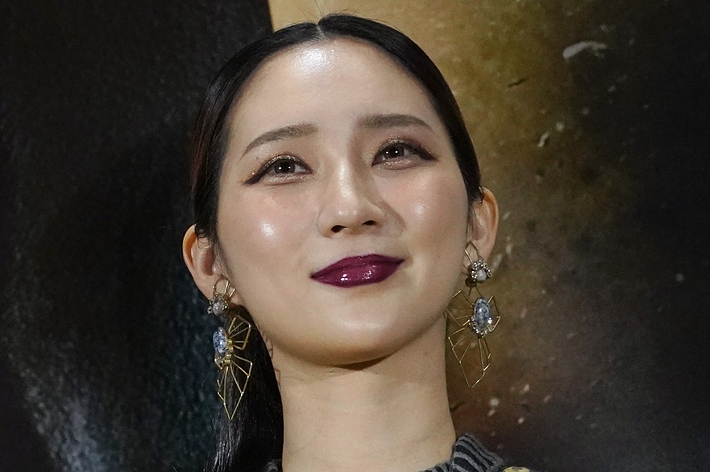 黒いドレスを着たKimikoが赤い口紅をつけた笑顔の写真。